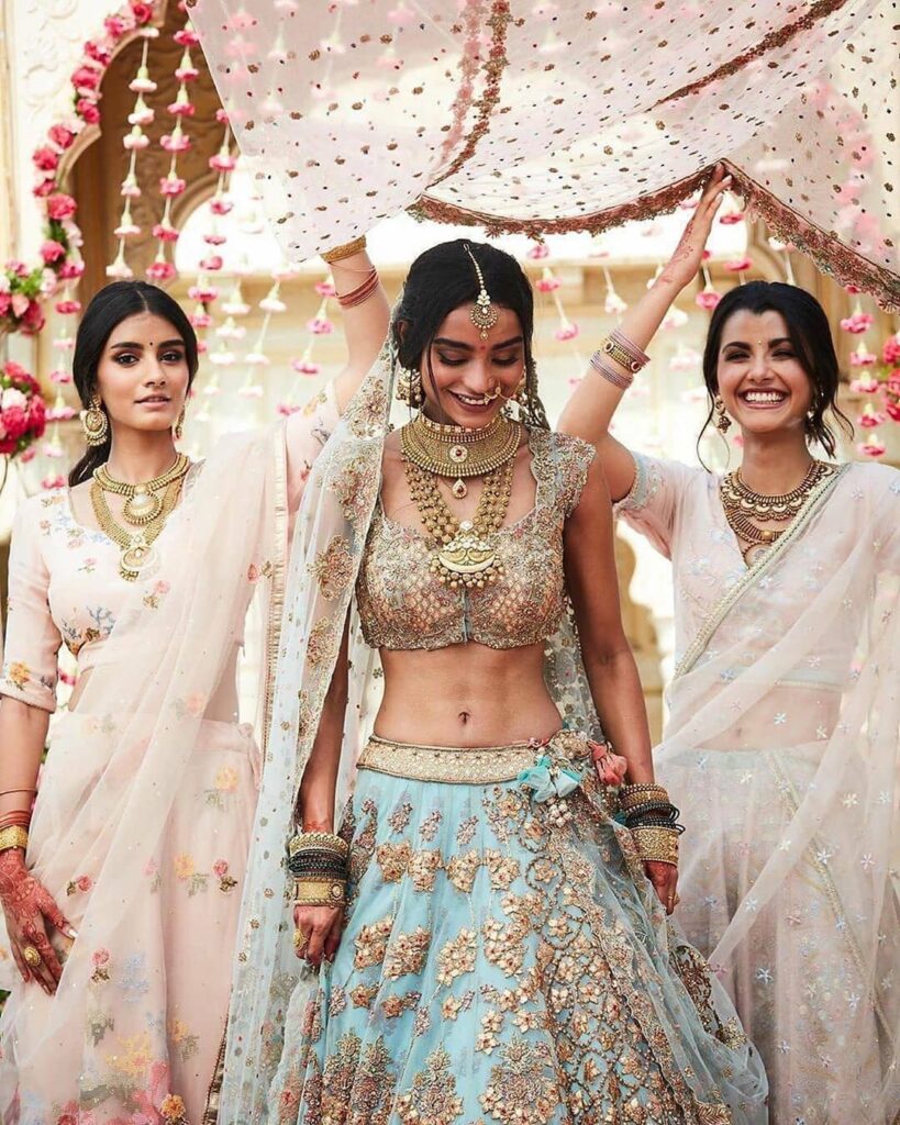 Friends holding phoolon ki chadar, bride with bridesmaids