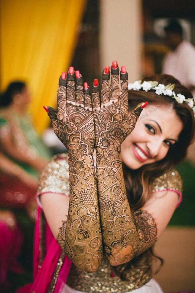 Photo of Bride showing off traditional bridal mehendi