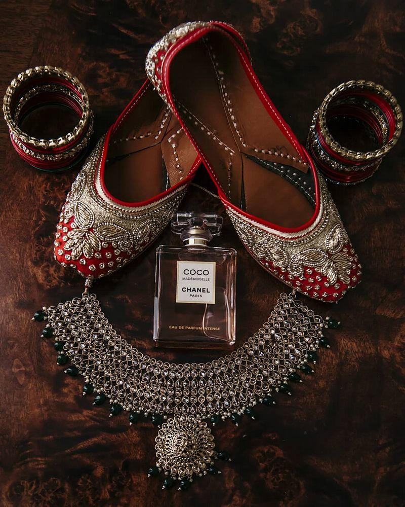Photo of bridal shoes perfume and juttis with jewellery