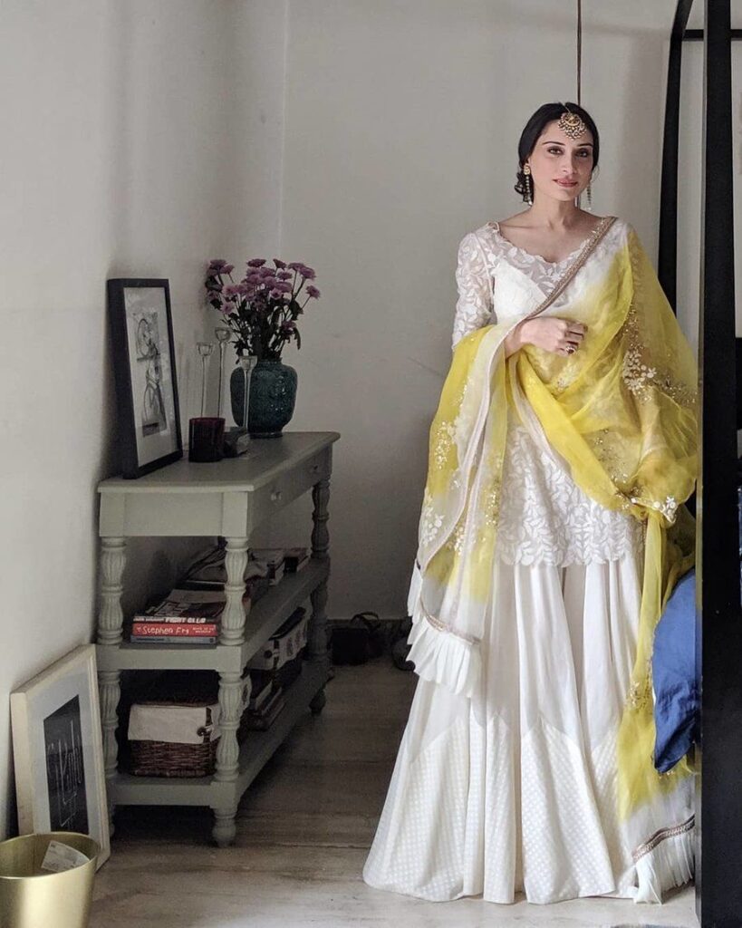 Bride in a short white kurta and sharara pants on her haldi function