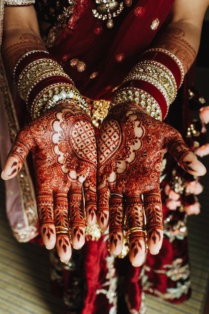 Free Photo | Traditional indian heart ornament on hands colored by henna and bridal bracelets in bordeaux colours